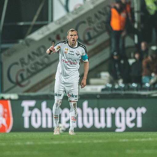 Fußballspieler des SK Sturm Graz mit angelegtem Arm und erhobenem Zeigefinger auf dem Spielfeld