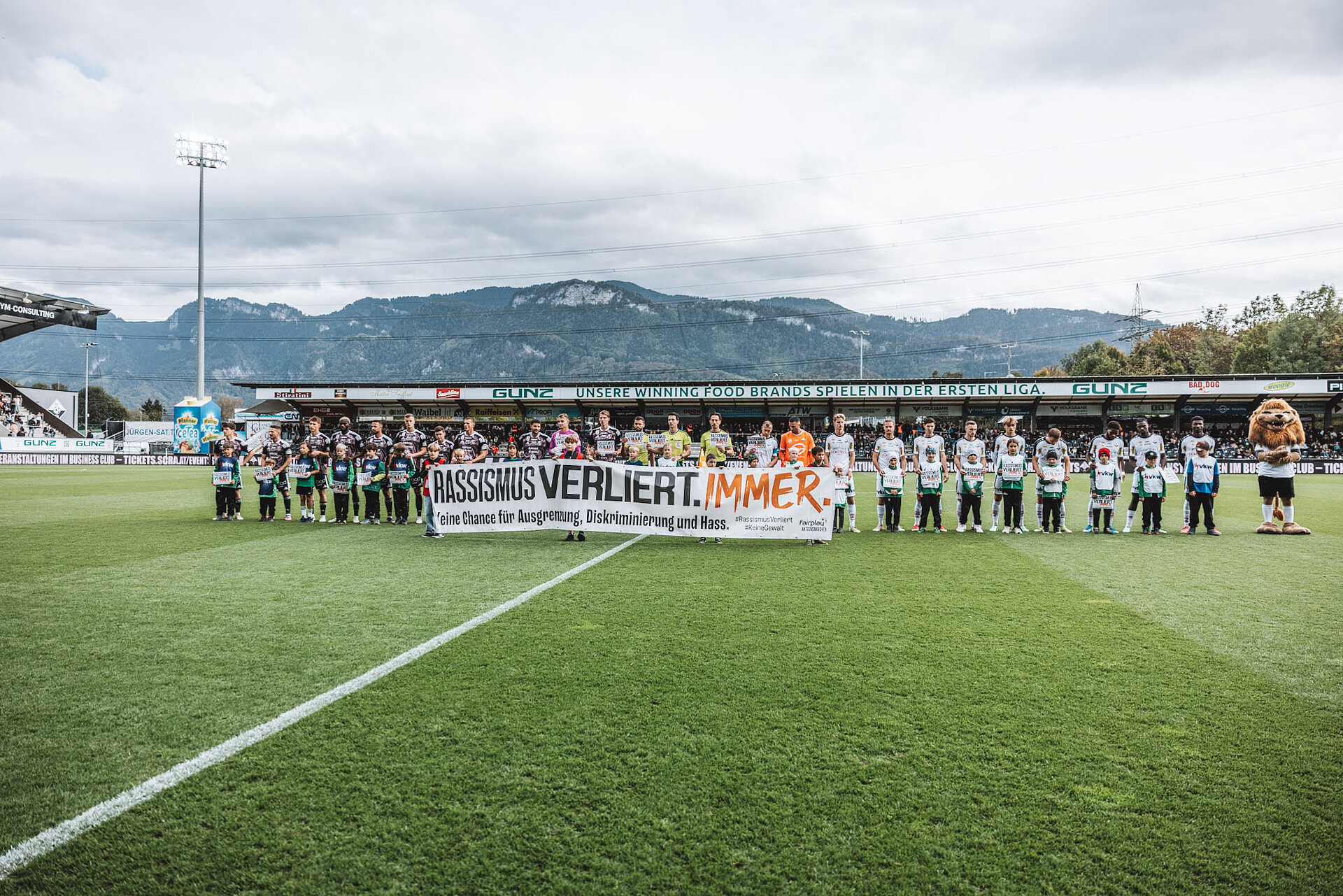 Fußballmannschaft mit Kindern und Spruchband "Rassismus verliert immer" in Österreich